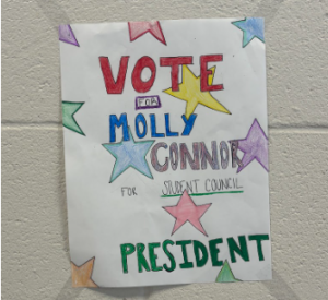 A campaign poster created by Molly Conner (26) for student council President stands alone in the cafeteria stairwell. 